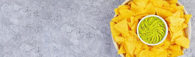 Mexican nachos with cheese. Corn chips with guacamole, salsa and tomato ketchup. photo