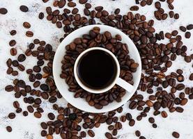 Coffee cup and coffee beans on white background. Top view. Flat lay photo