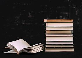 Stack of different books on dark background. Knowledge concept. photo