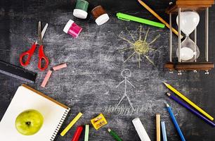 Background of dirty chalkboard. School concept with stationery supplies. photo