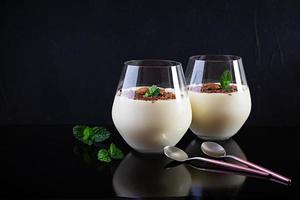Sweet milk pudding with almonds and chocolate chips isolated on dark background photo
