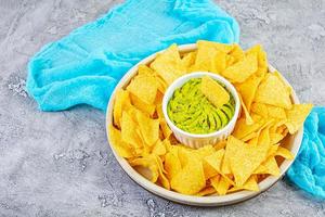 Mexican nachos with cheese. Corn chips with guacamole, salsa and tomato ketchup. photo