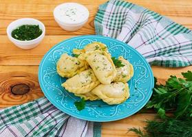 Delicious dumplings with cabbage on wooden background photo