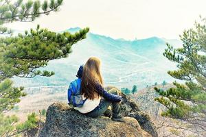 Girl sits on a rock photo