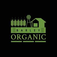an emblem logo for organic farming product or company depicting a barn and a windmill in the middle of a wheat or barley field all in green color on dark ground