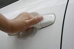 woman's hand opens white car door. close up. photo