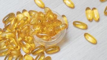 Fish oil capsules on wood background and texture. photo