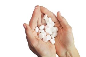 A handful of white round pills in the palms on a white background. The concept of health and medicine, treatment, pharmaceuticals. photo