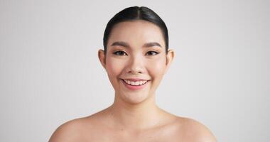 närbild av skönhet asiatisk kvinna ansikte tittar på camera.beautiful kvinnlig modell med perfekt ren fräsch hud. hudvårdsbehandling eller kosmetiska annonser koncept. video