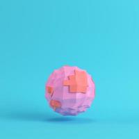 Pink abstract low poly planet on bright blue background in pastel colors photo