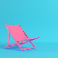 Pink beach chair on bright blue background in pastel colors photo