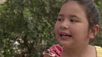 menina sorrindo olhando para a câmera enquanto come sorvete video