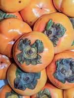 fresh persimmons on a kitchen table photo