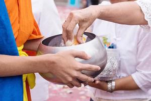 Gives food to Buddhist monk. photo
