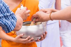 Gives food to Buddhist monk. photo