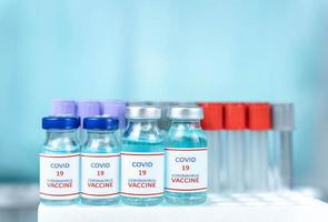 cierre una botella de vacuna puesta sobre la mesa del laboratorio científico, un concepto de uso de drogas para tratar y proteger la pandemia mundial de covid-19 foto