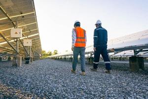 Engineers with investor walk to check the operation of the solar farm,solar panel systems, Alternative energy to conserve the world is energy, Photovoltaic module idea for clean energy production photo