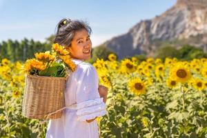 Girls travel in fields of blooming yellow sunflowers in the summer season in sunflowers farm and other flowers photo