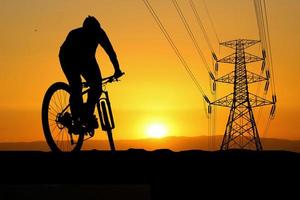 siluetas de bicicletas de montaña y ciclistas por la noche felizmente. concepto de viaje y fitness foto