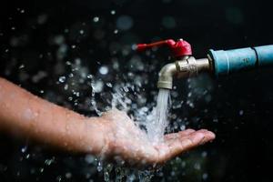 Good water management ideas make us have water to use forever. faucet with running water On a black background there is a copy space. photo