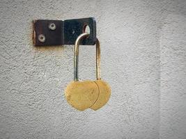 Two hearts padlock love symbol hanging on textured wall photo