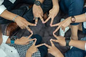 The hands of one family are making a star shape, with both the hands of adults and children. photo