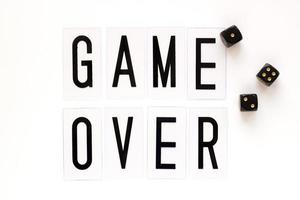 GAME OVER text with gaming dice on white background. Concept for banners, web pages, games, presentation. Top view photo