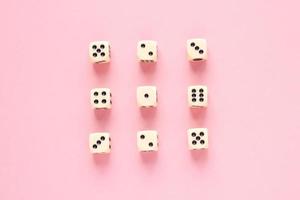 Gaming dice organized in rows on pink background in flat style. Concept for banners, web, games, web, presentation. Top view. photo