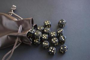 Close-up set of gaming dice rolled out of leather bag on dark background. Concept with copy space for games photo