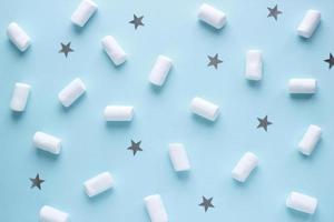 Geometric pattern of white marshmallows and stars on blue pastel background. Food concept in minimal flatlay style photo