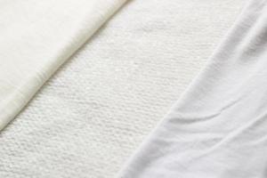 textil blanco arrugado de primer plano para el fondo. diferentes texturas de telas con pliegues. vista superior foto