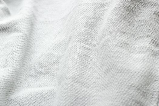 Crumpled white textile with folded for background. Top view material texture. Close-up minimalistic concept. photo
