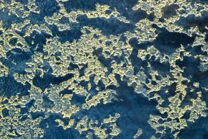 Abstract texture of decorative plaster. Grunge background of stucco texture. Blue with gold colored surface photo