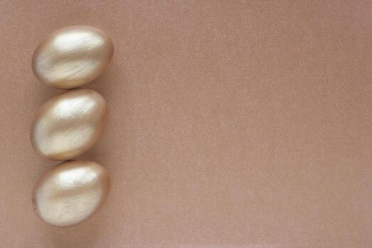 Golden eggs with copy space for text on bronze background. Top view concept with bronze eggs in flat lay style. Idea for greetings and Easter photo