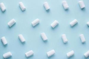 Geometric pattern of white marshmallows on blue pastel background. Food concept in minimal flatlay style photo