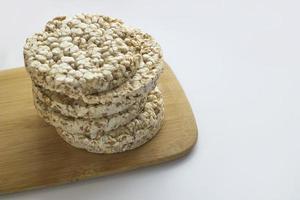 Stack of round rice crispbreads on wooden board. Concept of healthy diet with copy space photo