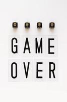 GAME OVER text and gaming dice with image skull on white background. Concept for banners, web pages, games, presentation. Top view photo