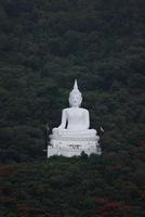 el punto de vista frente al buda blanco está en medio de una colina de bosque verde. wat phra khao en nakhon ratchasima, tailandia, el 16-05-2022 foto