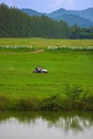 Driving in the green fields behind the mountains with bright blue skies. photo