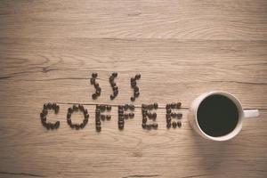 Top view Coffee beans are arranged in alphabetical terms, coffee and coffee cup laid on a wooden table. photo