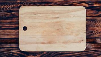 Wooden cutting board on brown table background photo