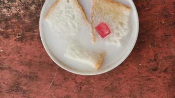 wedang asle comida servida en un tazón lleno de leche mezclada con arroz pegajoso y unas rebanadas pequeñas de pan blanco foto