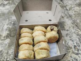 rows of bakpia pathok neatly arranged in a small cardboard container photo