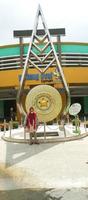 Yogyakarta - June 9, 2022 - Asian woman standing in front of the golden gong monument photo