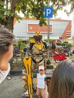 sukoharjo - 2 de junio de 2022 - retrato de un niño pequeño que lleva una espada frente a un robot foto