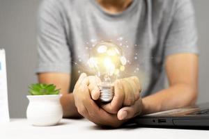 Man holding light bulbs, ideas of new ideas with innovative technology and creativity photo