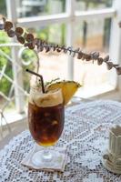 selective focus, Glass of iced drink on table, summer cocktail recipe, refreshment concept. Cold drink Black Coffee is the New exotic Iced Coffee With Pineapple Juice. photo