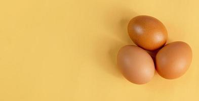 Eggs are laid in groups of three, eggshells with different patterns. Shot in a studio with light and shadows against an eggshell colored background. photo