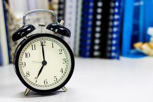 Reloj de las 7 am en el escritorio de trabajo en el tiempo de oficina del hombre de negocios conceptos de trabajo espacio de copia de reloj selectivo foto