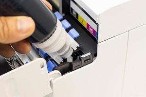 Technicians are installing setup the ink and Insert ink into the fill hole. of an inkjet printer, the device of office automate for printing photo